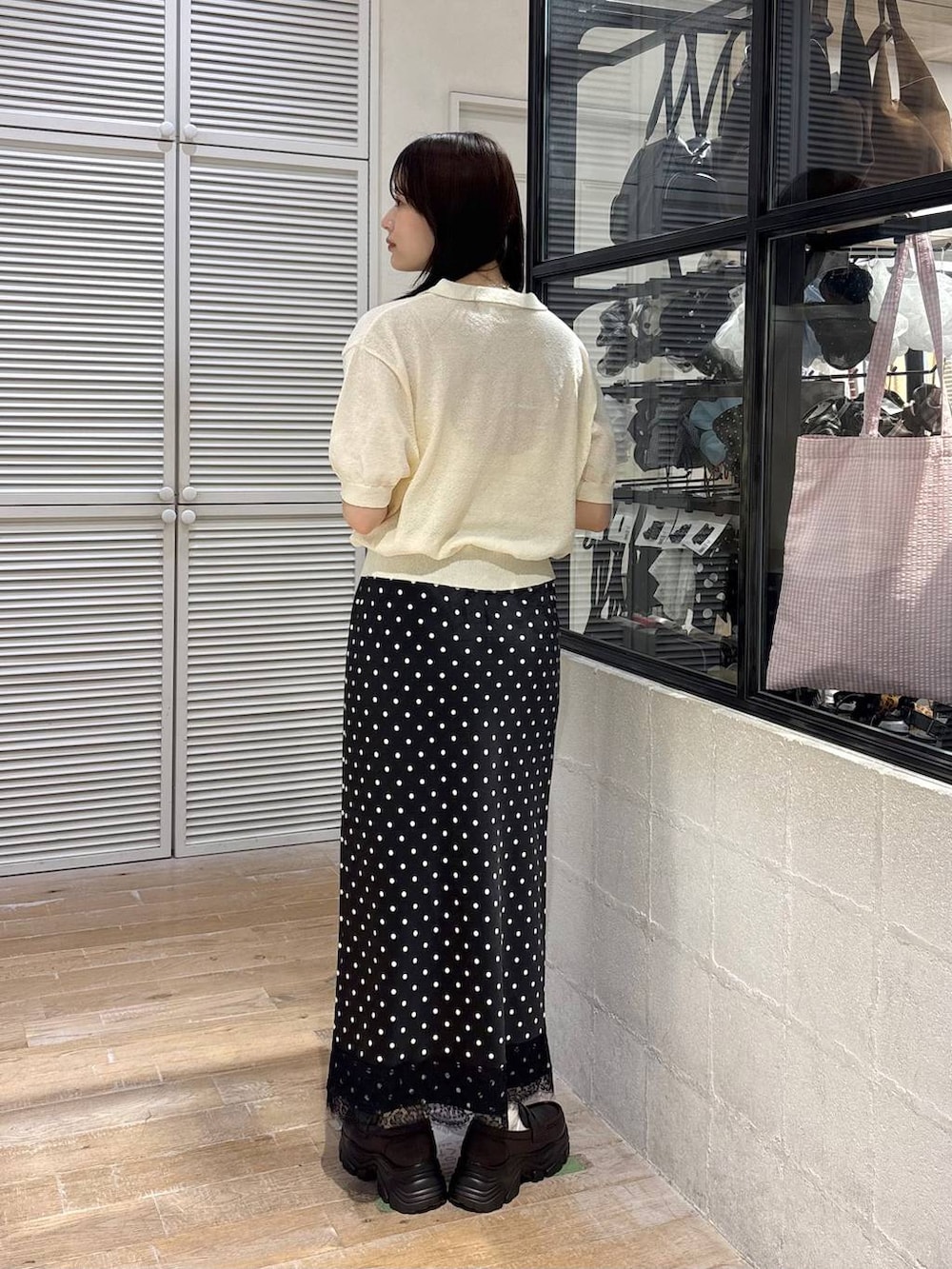 ブラウン系のショルダーバッグ、ブラウン系のローファー、ホワイト系のTシャツ/カットソーを着用したレディースの春コーディネートの5枚目の写真