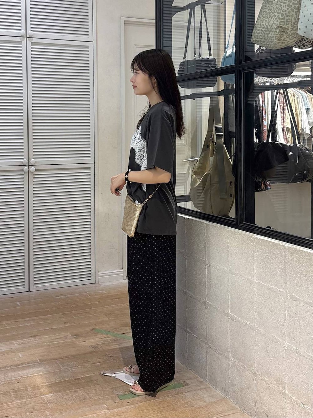 ゴールド系のショルダーバッグ、グレー系のTシャツ/カットソー、ホワイト系のサンダルを着用したレディースの夏コーディネートの4枚目の写真