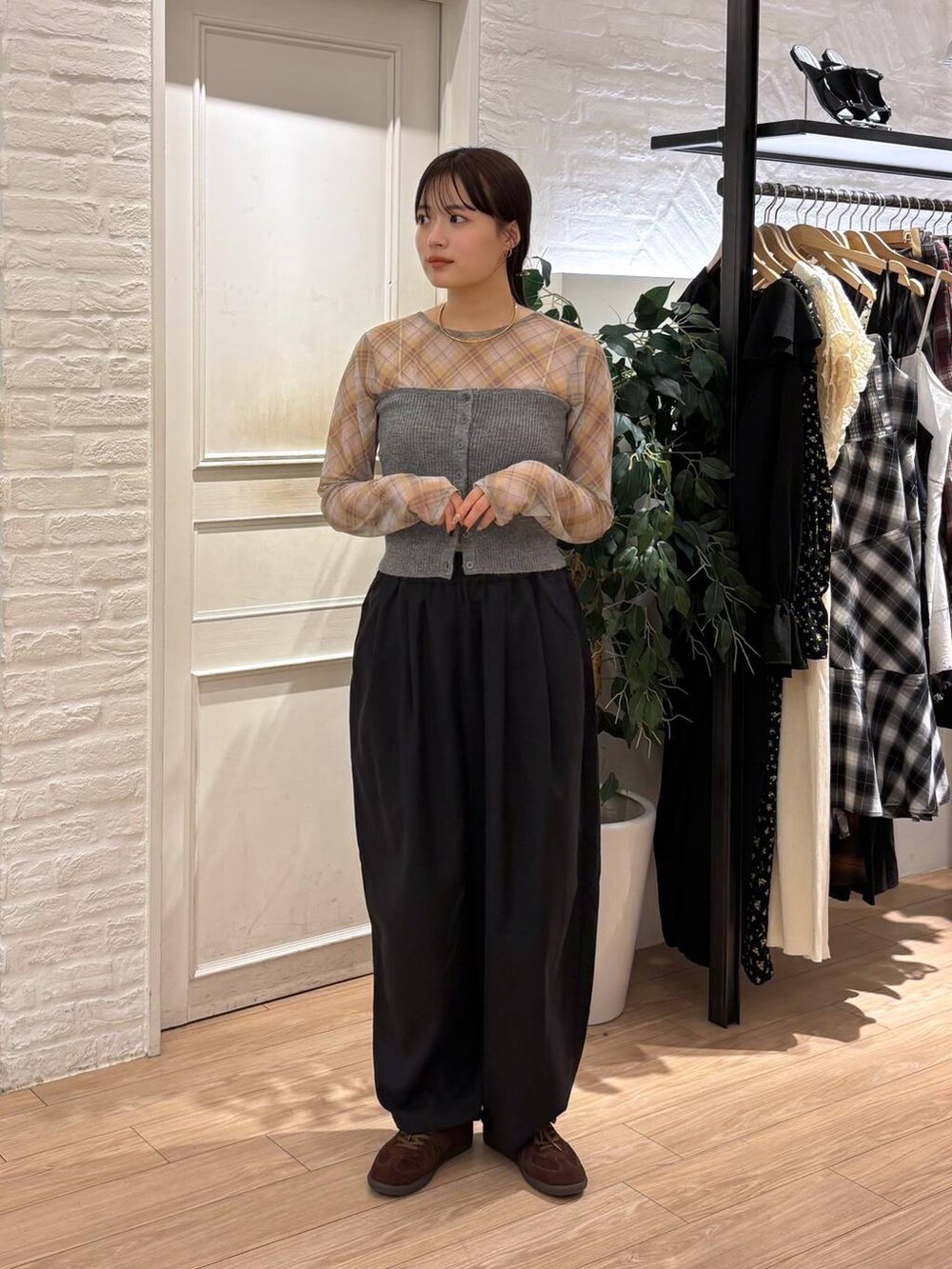 ブラウン系のスニーカー、ブラック系のその他パンツ、グレー系のチューブトップを着用したレディースの秋コーディネートの2枚目の写真