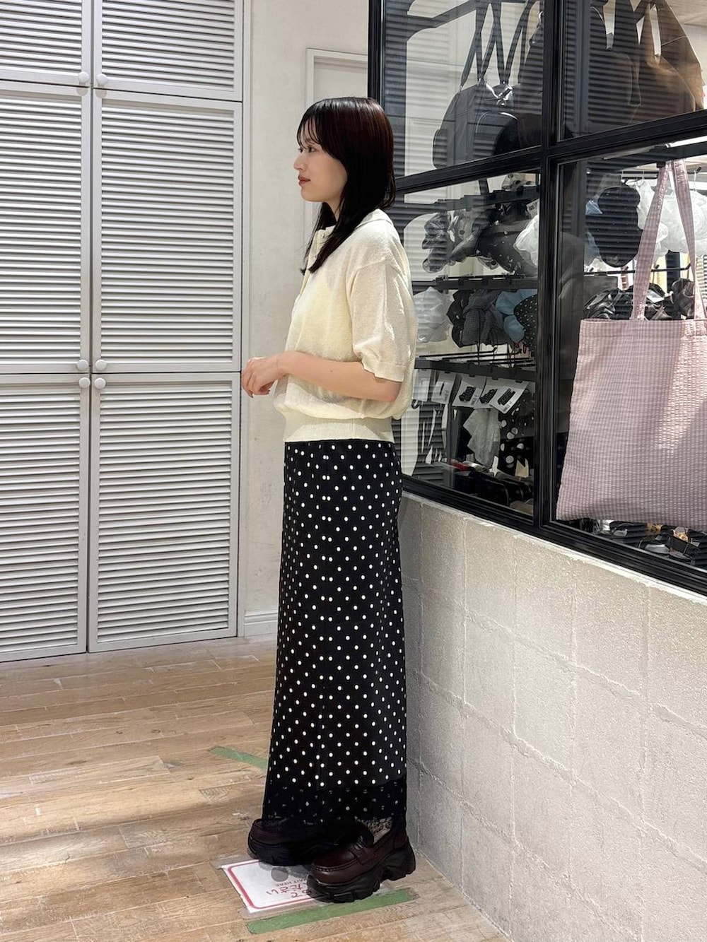ブラウン系のショルダーバッグ、ブラウン系のローファー、ホワイト系のTシャツ/カットソーを着用したレディースの春コーディネートの4枚目の写真