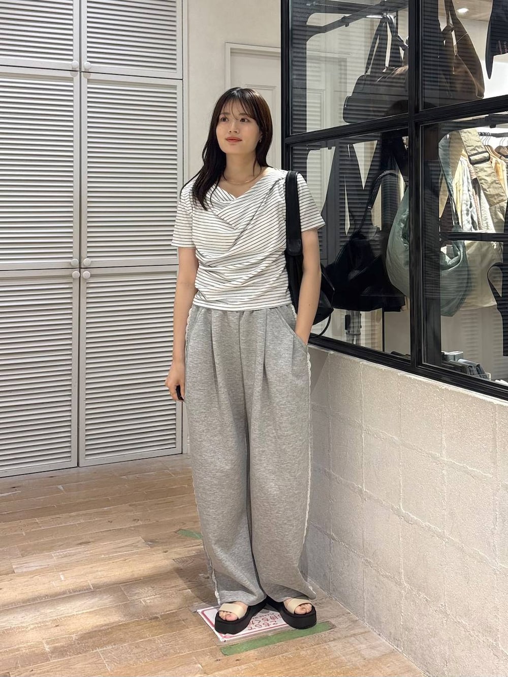 グレー系のスウェットパンツ、ホワイト系のサンダル、ホワイト系のTシャツ/カットソーを着用したレディースの春コーディネートの5枚目の写真