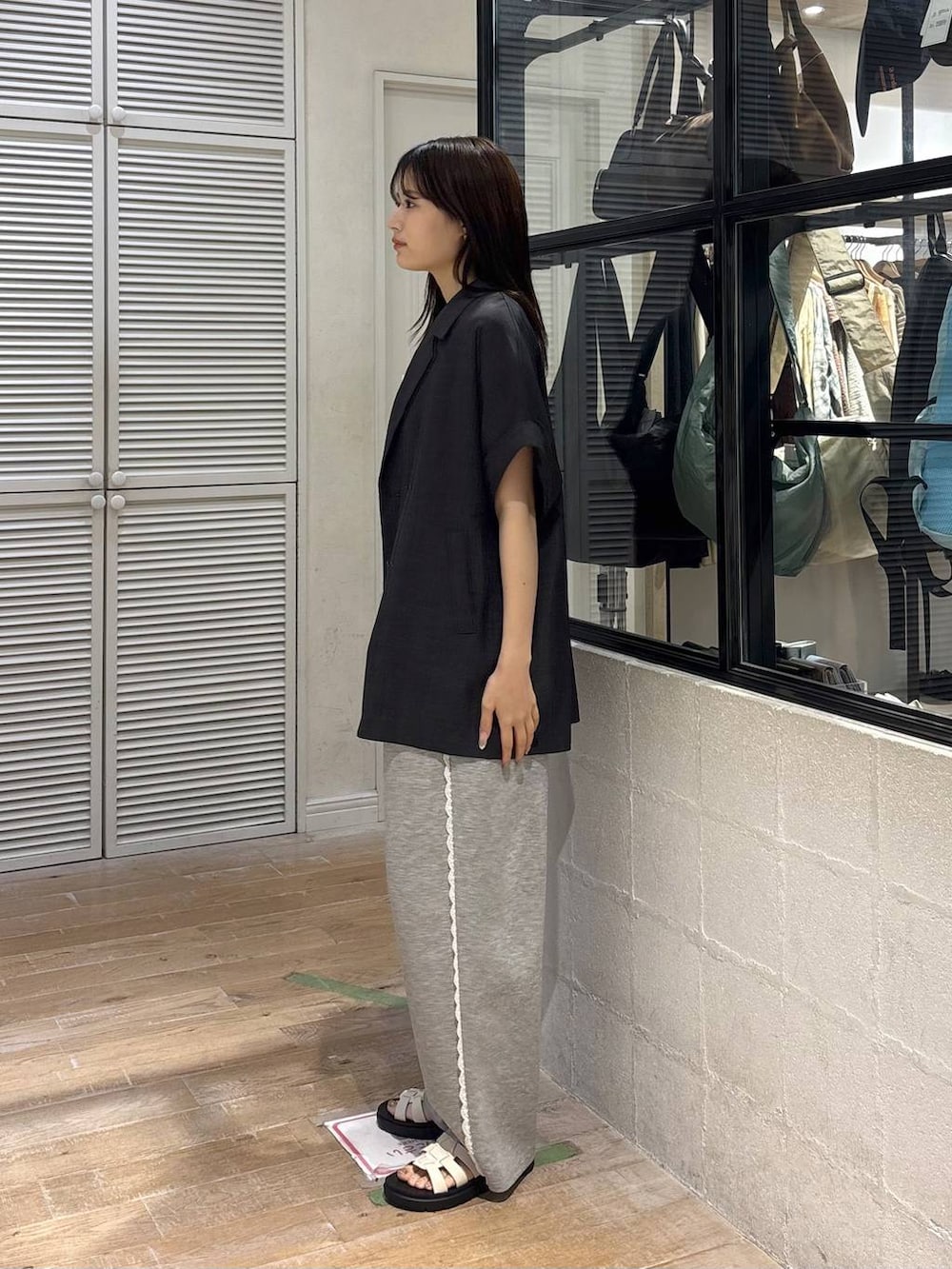 グレー系のスウェットパンツ、グレー系のテーラードジャケット、ホワイト系のサンダルを着用したレディースの夏コーディネートの3枚目の写真