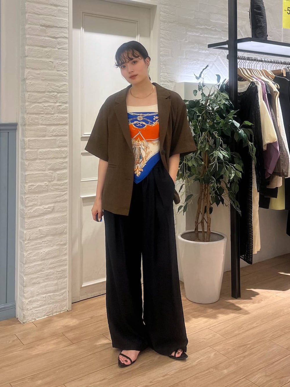 ブラウン系のテーラードジャケット、ブラック系のサンダル、ブラック系のその他パンツを着用したレディースの夏コーディネートの2枚目の写真