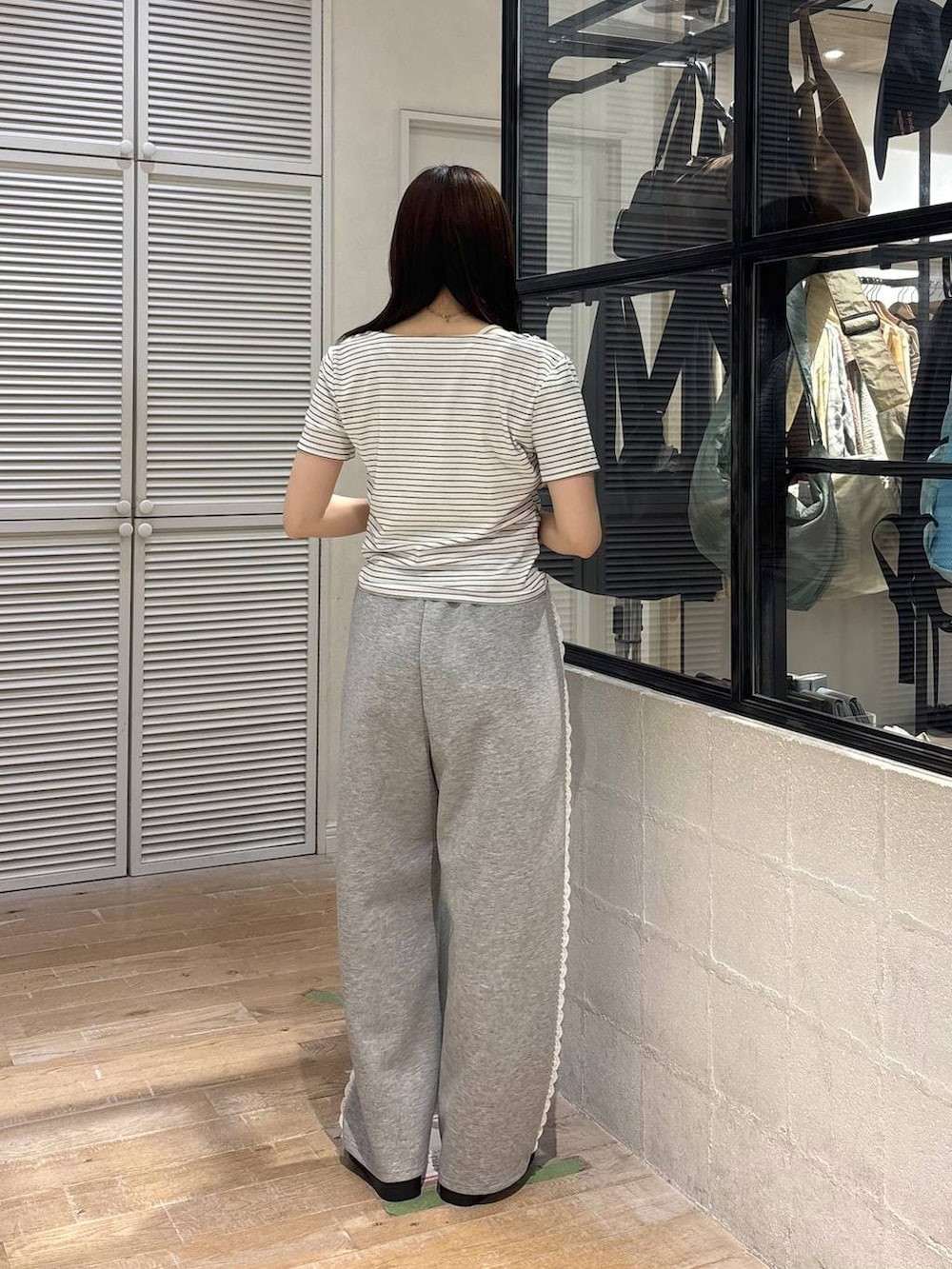 グレー系のスウェットパンツ、ホワイト系のサンダル、ホワイト系のTシャツ/カットソーを着用したレディースの春コーディネートの4枚目の写真