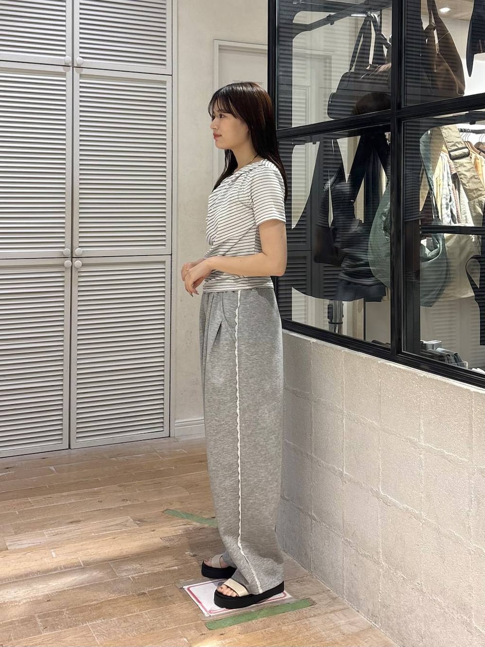 グレー系のスウェットパンツ、ホワイト系のサンダル、ホワイト系のTシャツ/カットソーを着用したレディースの春コーディネートの3枚目の写真