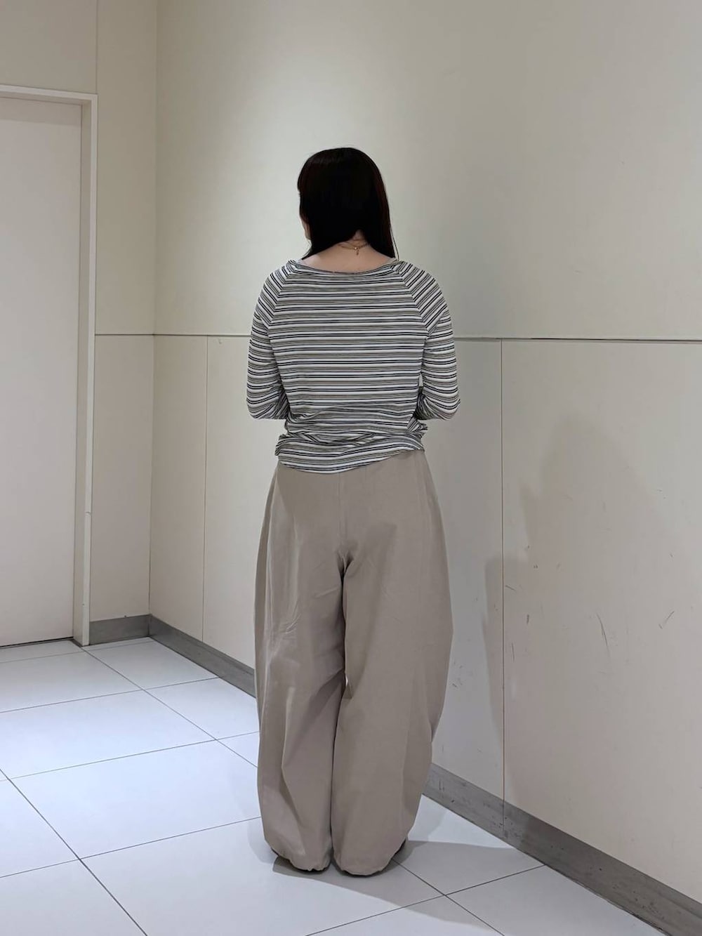 ホワイト系のTシャツ/カットソー、ブラック系のショルダーバッグ、ベージュ系のその他パンツを着用したレディースの春コーディネートの5枚目の写真