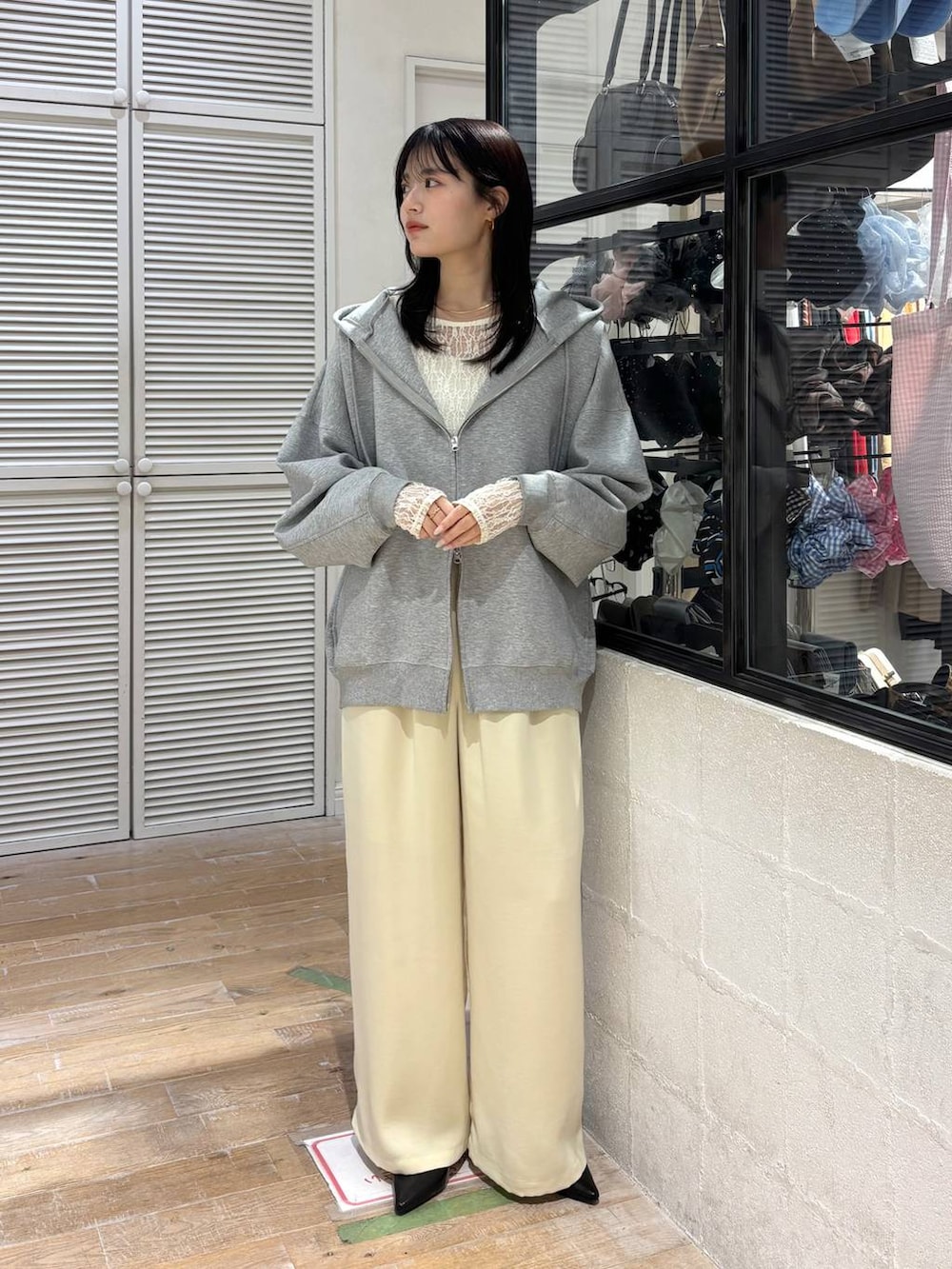 グレー系のパーカー、イエロー系のその他パンツ、ブラック系のサンダルを着用したレディースの春コーディネートの2枚目の写真