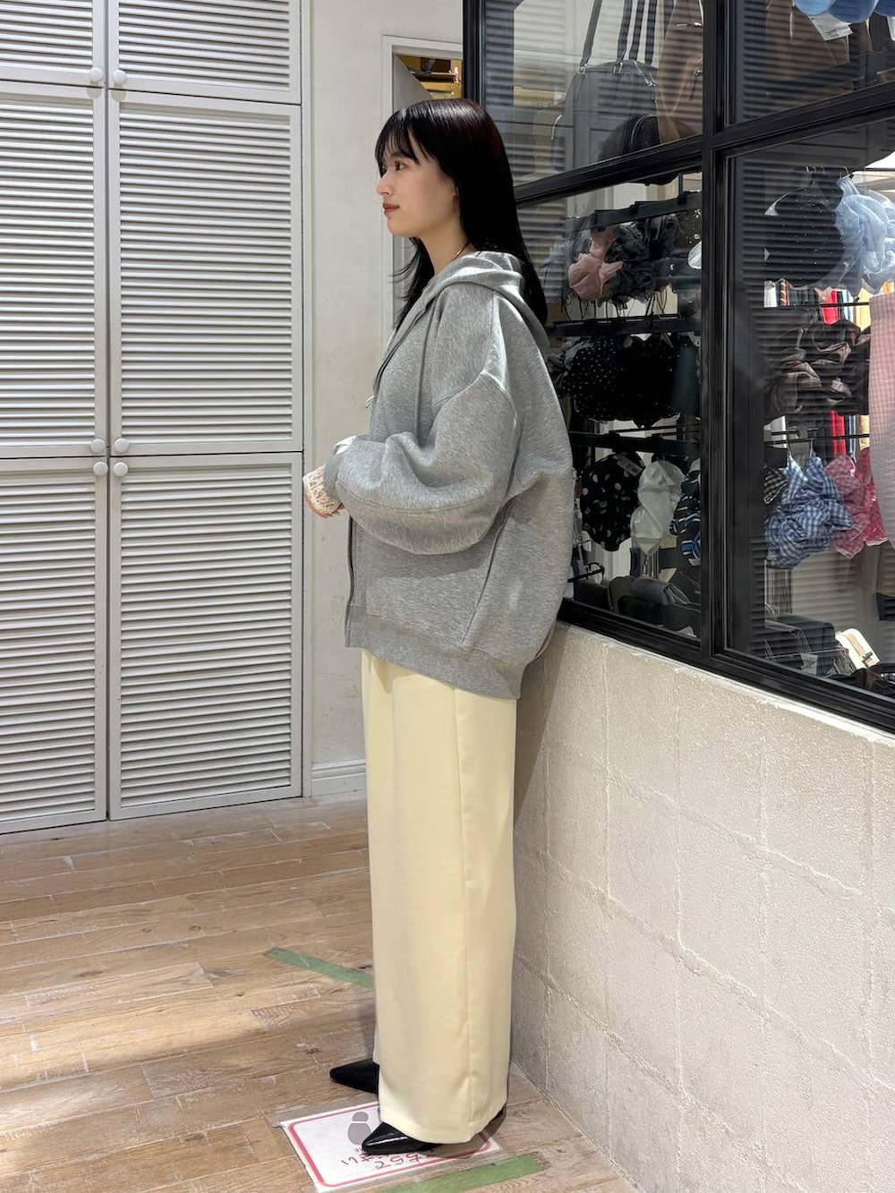 グレー系のパーカー、イエロー系のその他パンツ、ブラック系のサンダルを着用したレディースの春コーディネートの3枚目の写真