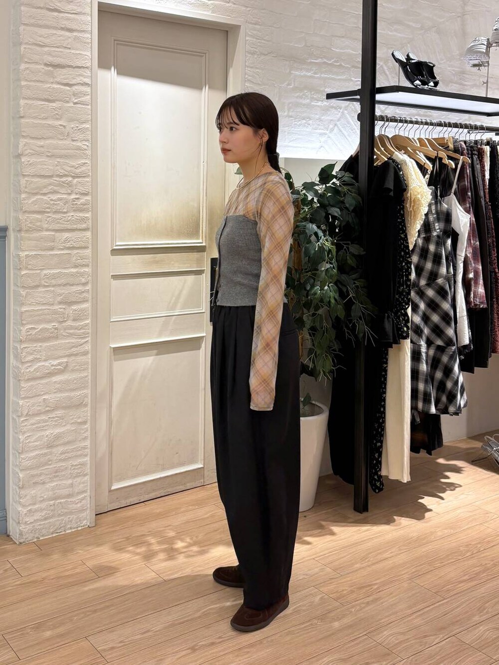 ブラウン系のスニーカー、ブラック系のその他パンツ、グレー系のチューブトップを着用したレディースの秋コーディネートの3枚目の写真