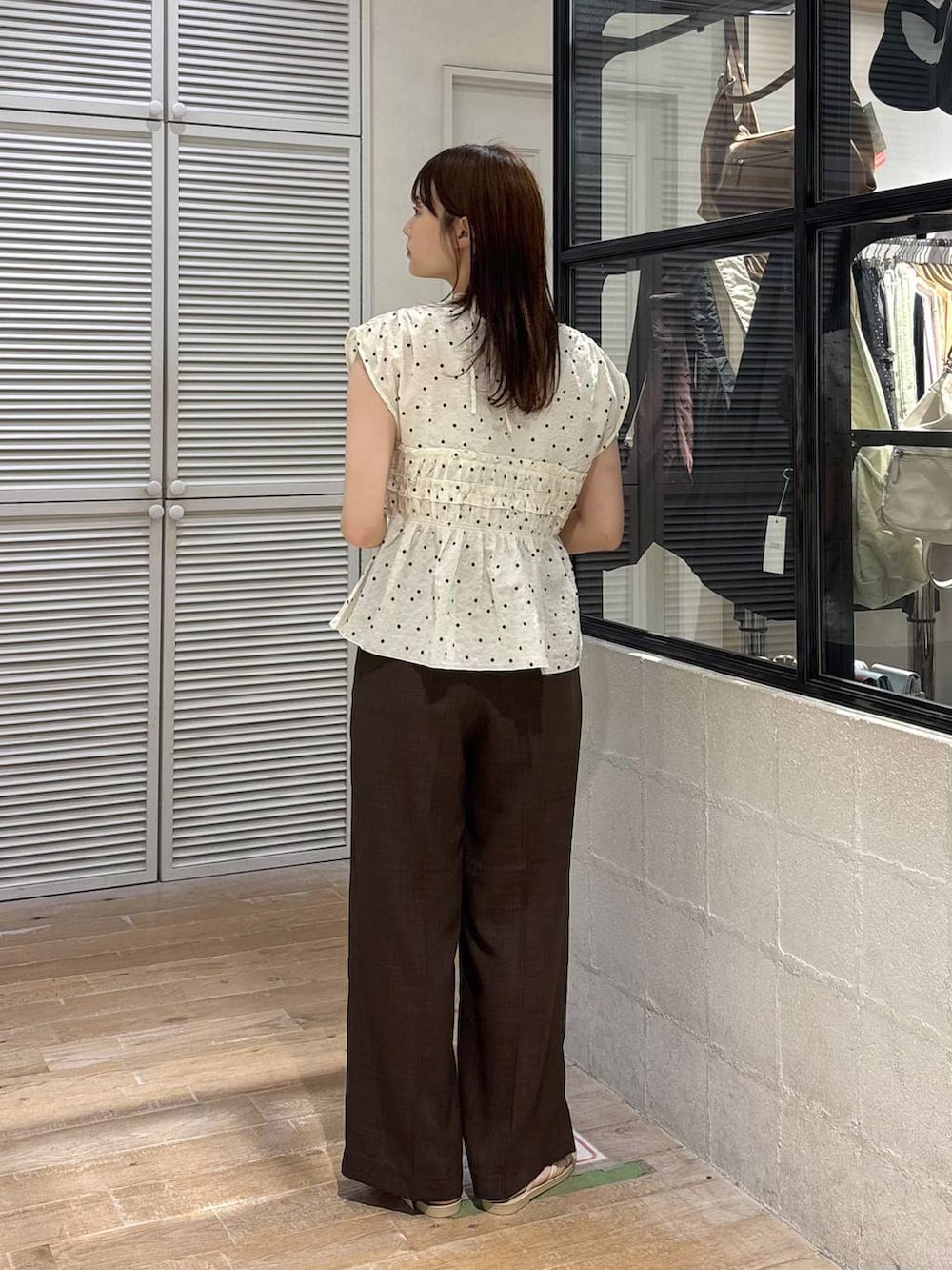 ブラウン系のスラックス、ホワイト系のサンダル、その他のシャツ/ブラウスを着用したレディースの夏コーディネートの3枚目の写真