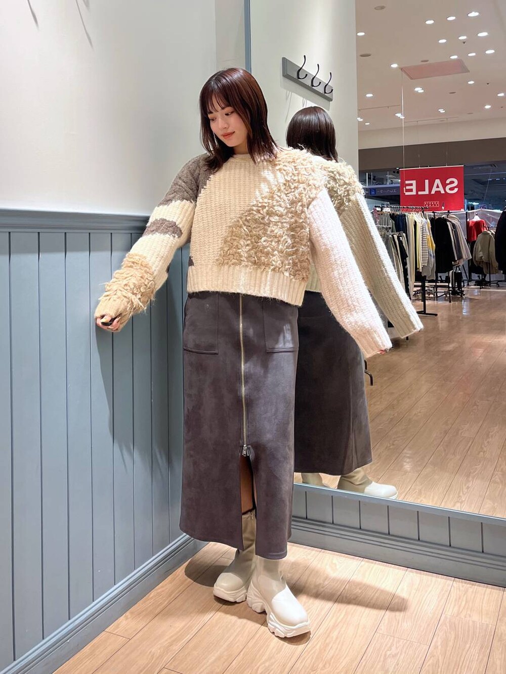 ホワイト系のブーツ、ブラック系のショルダーバッグ、グレー系のスカートを着用したレディースの冬コーディネートの2枚目の写真