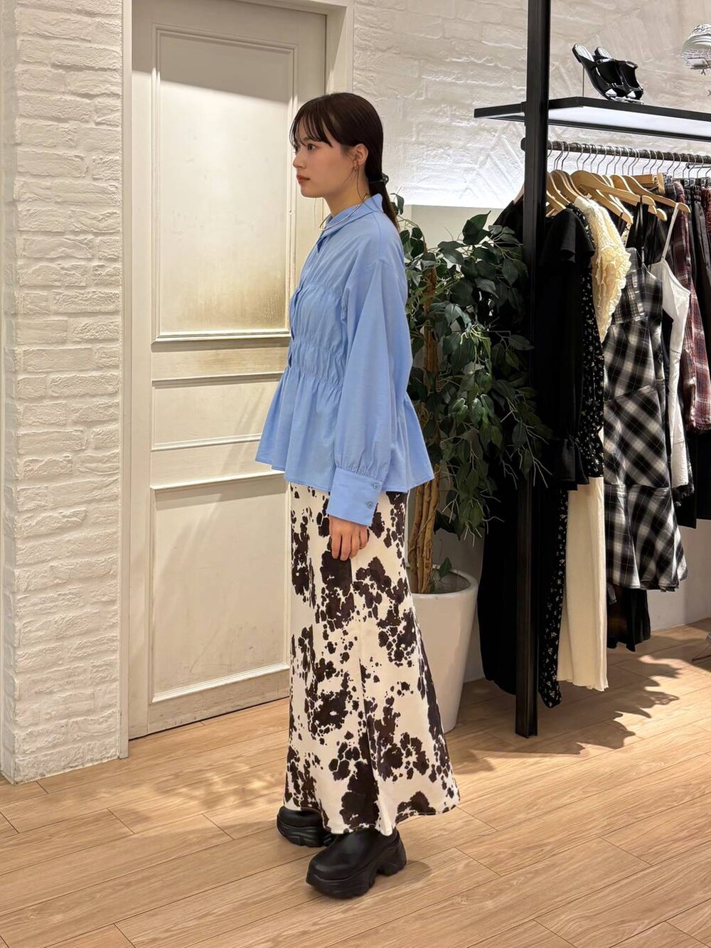 ブラック系のブーツ、その他のスカート、ブラック系のボストンバッグを着用したレディースの秋コーディネートの3枚目の写真