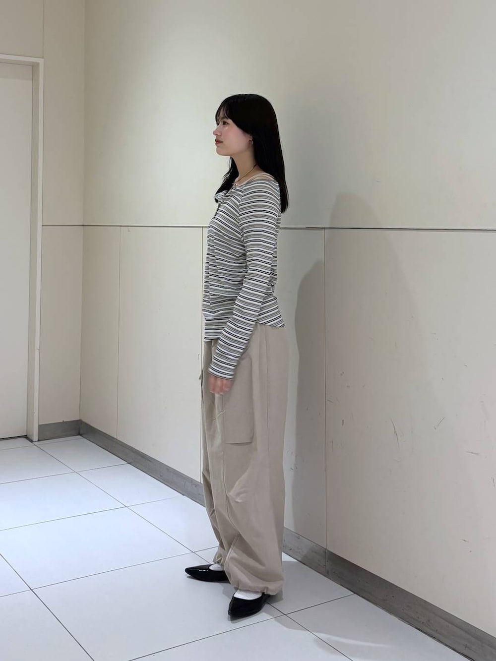 ホワイト系のTシャツ/カットソー、ブラック系のショルダーバッグ、ベージュ系のその他パンツを着用したレディースの春コーディネートの4枚目の写真