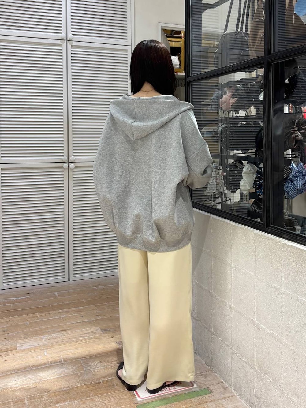 グレー系のパーカー、イエロー系のその他パンツ、ブラック系のサンダルを着用したレディースの春コーディネートの4枚目の写真