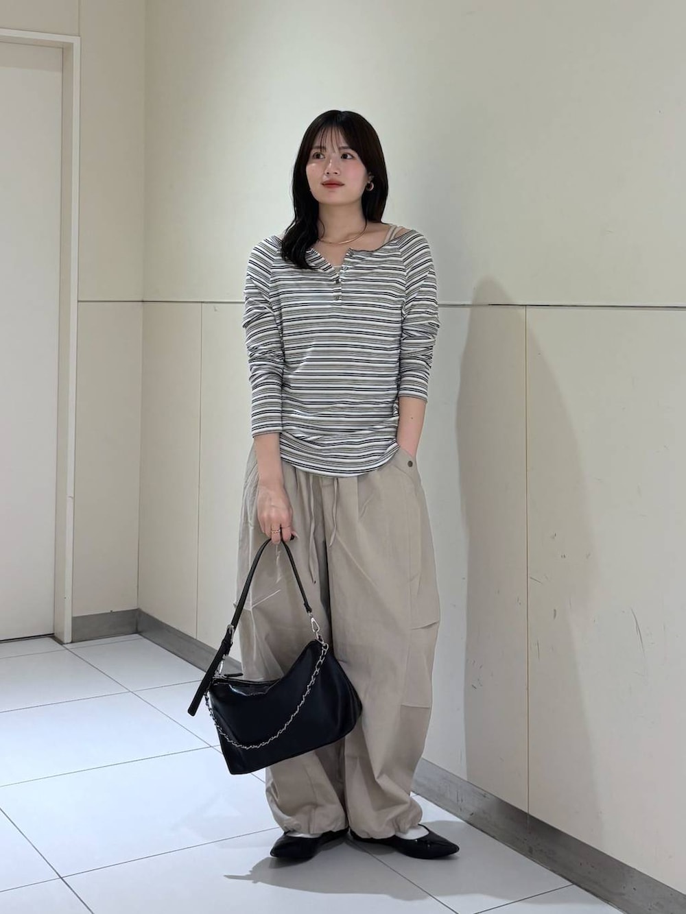 ホワイト系のTシャツ/カットソー、ブラック系のショルダーバッグ、ベージュ系のその他パンツを着用したレディースの春コーディネートの7枚目の写真