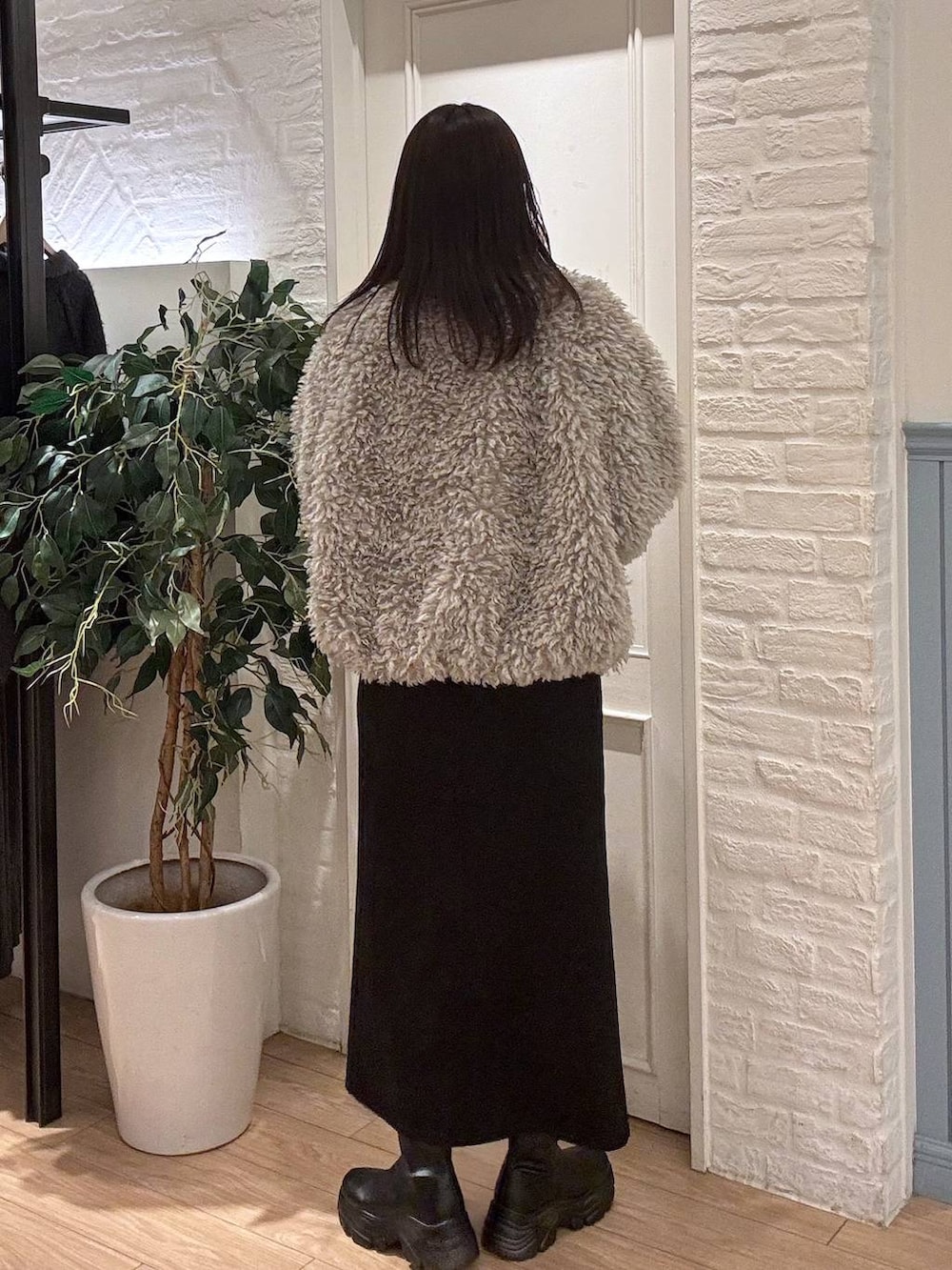 ブラック系のブーツ、ブラック系のスカート、グレー系のブルゾンを着用したレディースの冬コーディネートの4枚目の写真