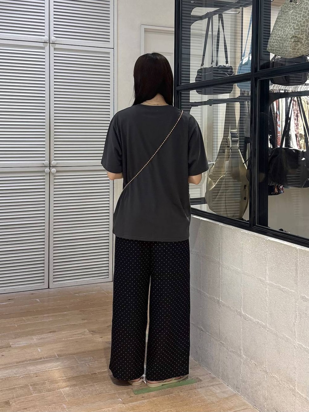 ゴールド系のショルダーバッグ、グレー系のTシャツ/カットソー、ホワイト系のサンダルを着用したレディースの夏コーディネートの5枚目の写真