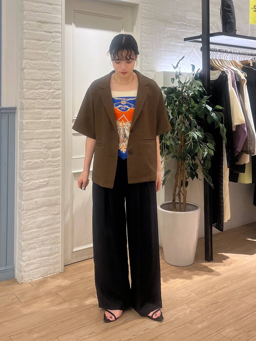 ブラウン系のテーラードジャケット、ブラック系のサンダル、ブラック系のその他パンツを着用したレディースの夏コーディネートの3枚目の写真