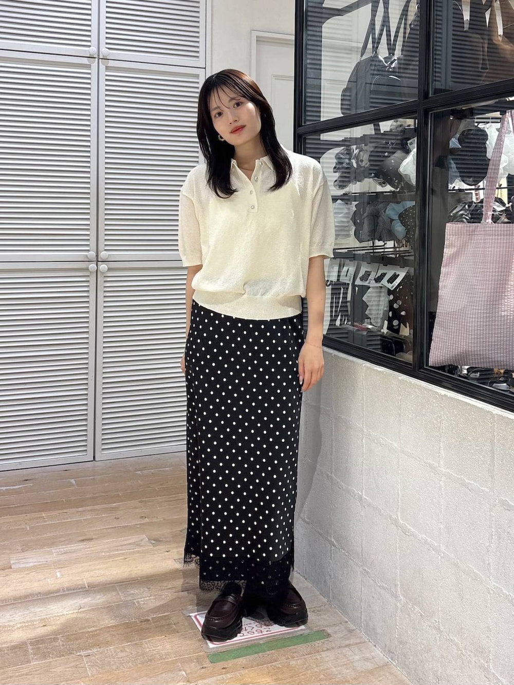 ブラウン系のショルダーバッグ、ブラウン系のローファー、ホワイト系のTシャツ/カットソーを着用したレディースの春コーディネートの3枚目の写真