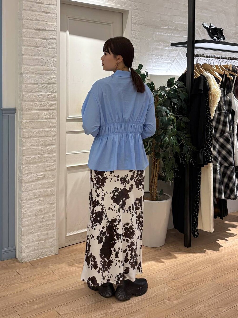 ブラック系のブーツ、その他のスカート、ブラック系のボストンバッグを着用したレディースの秋コーディネートの4枚目の写真