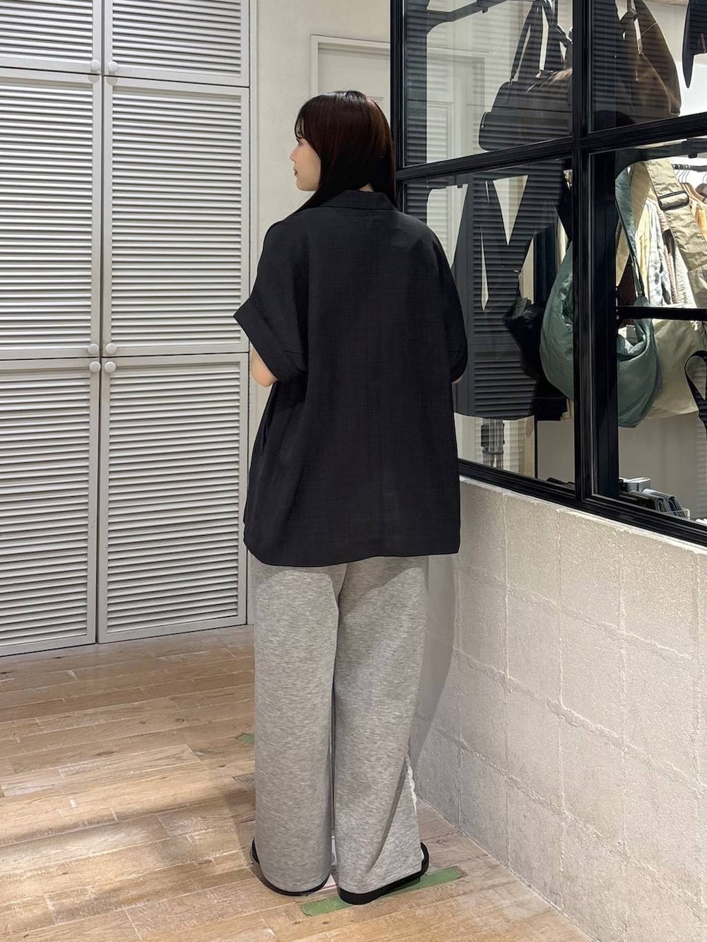 グレー系のスウェットパンツ、グレー系のテーラードジャケット、ホワイト系のサンダルを着用したレディースの夏コーディネートの4枚目の写真