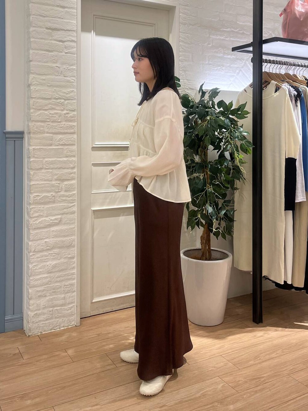 ホワイト系のシャツ/ブラウス、ブラウン系のスカートを着用したレディースの春コーディネートの2枚目の写真