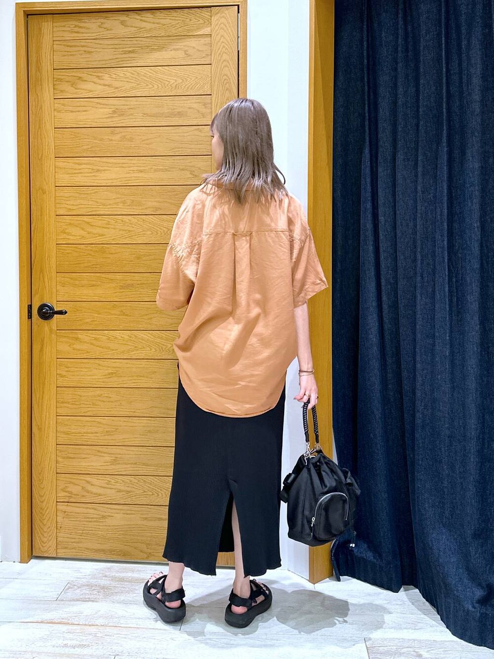 ブラック系のスカート、ブラック系のサンダル、レッド系のシャツ/ブラウスを着用したレディースの夏コーディネートの3枚目の写真