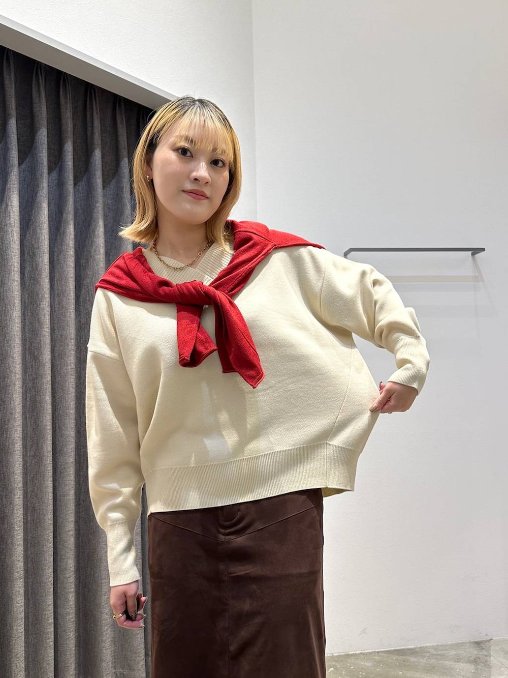 ブラウン系のスカート、ホワイト系のニット/セーター、ブラック系のトートバッグを着用したレディースの秋コーディネートの5枚目の写真