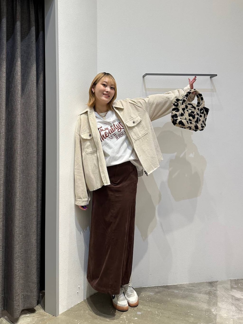 ブラウン系のスカート、ホワイト系のTシャツ/カットソー、ホワイト系のブルゾンを着用したレディースの秋コーディネートの5枚目の写真