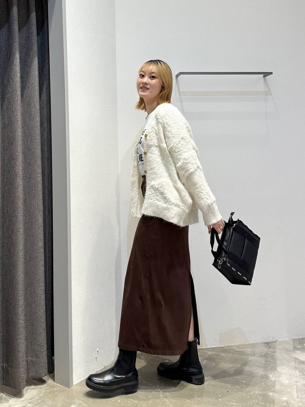 ホワイト系のTシャツ/カットソー、ブラウン系のスカート、ブラック系のトートバッグを着用したレディースの秋コーディネートの2枚目の写真