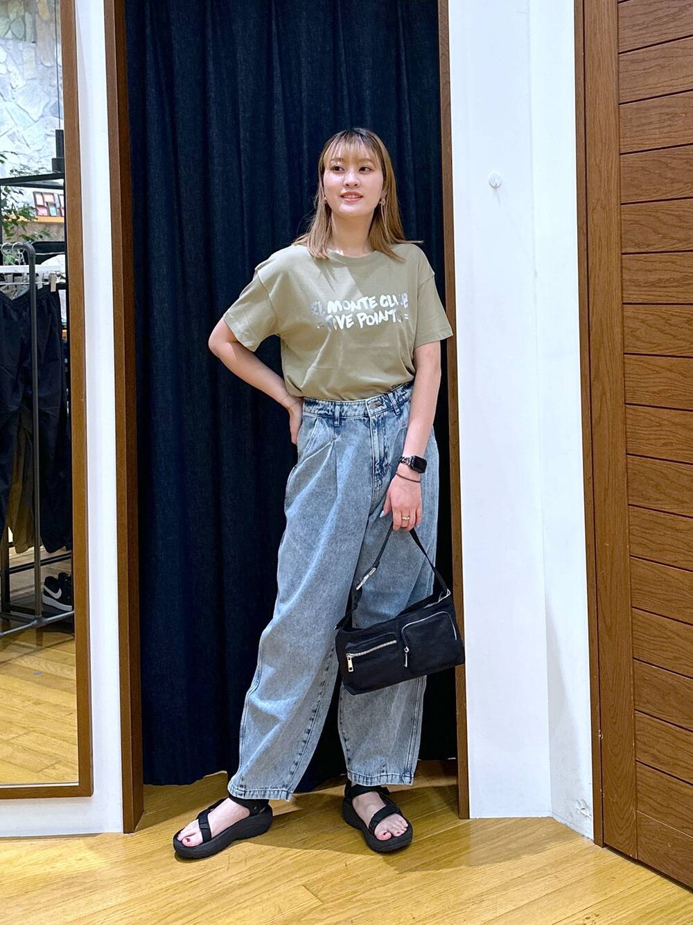 ブラック系のショルダーバッグ、グリーン系のTシャツ/カットソー、ブラック系のサンダルを着用したレディースの夏コーディネートの4枚目の写真