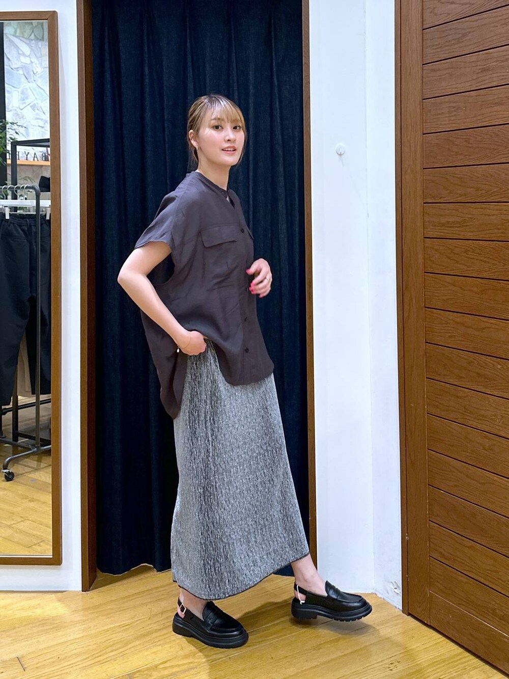 シルバー系のスカート、ブラウン系のシャツ/ブラウス、ブラック系のローファーを着用したレディースの春コーディネートの2枚目の写真