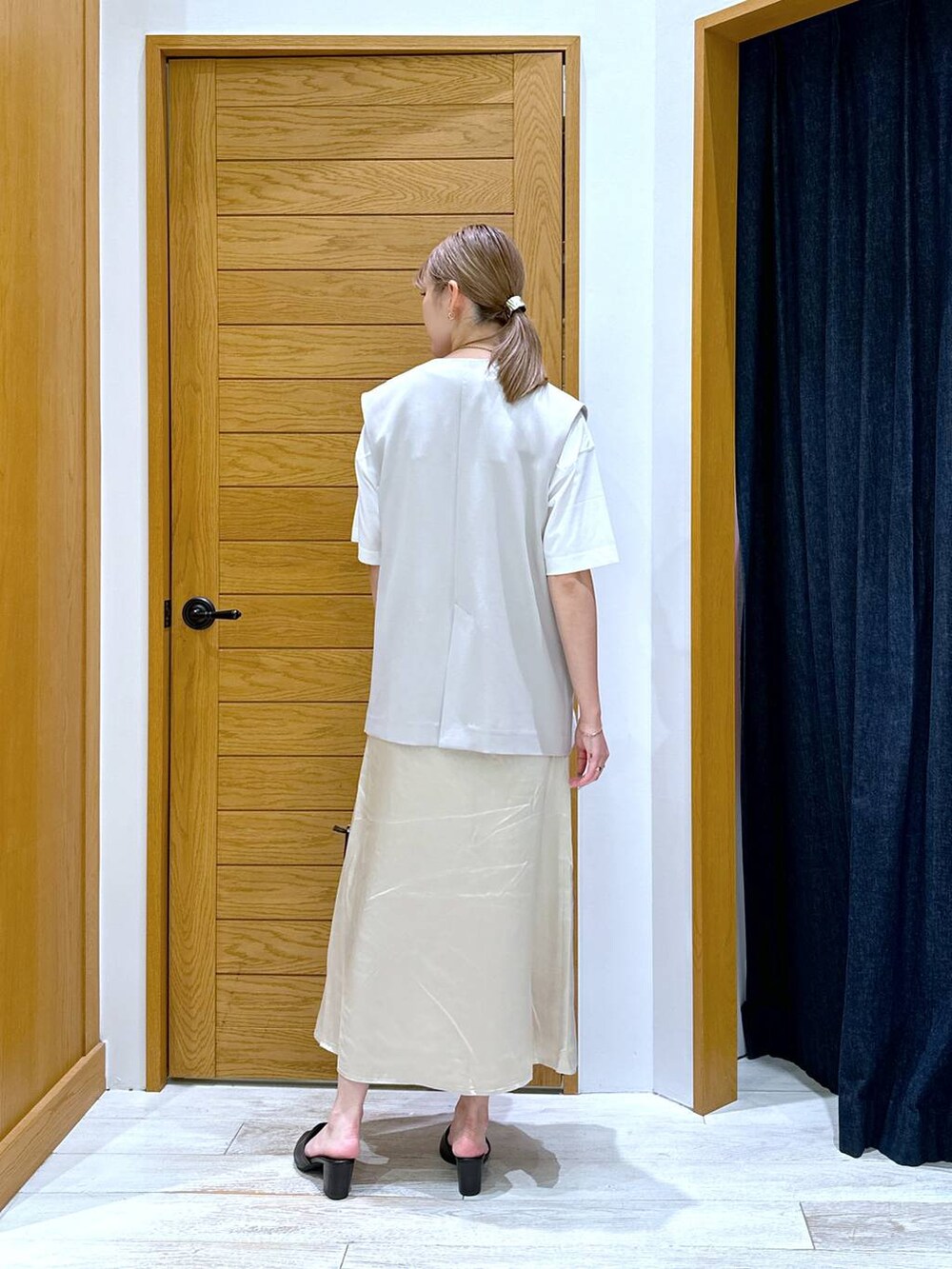 ホワイト系のTシャツ/カットソー、ブラック系のショルダーバッグ、ベージュ系のベストを着用したレディースの秋コーディネートの3枚目の写真