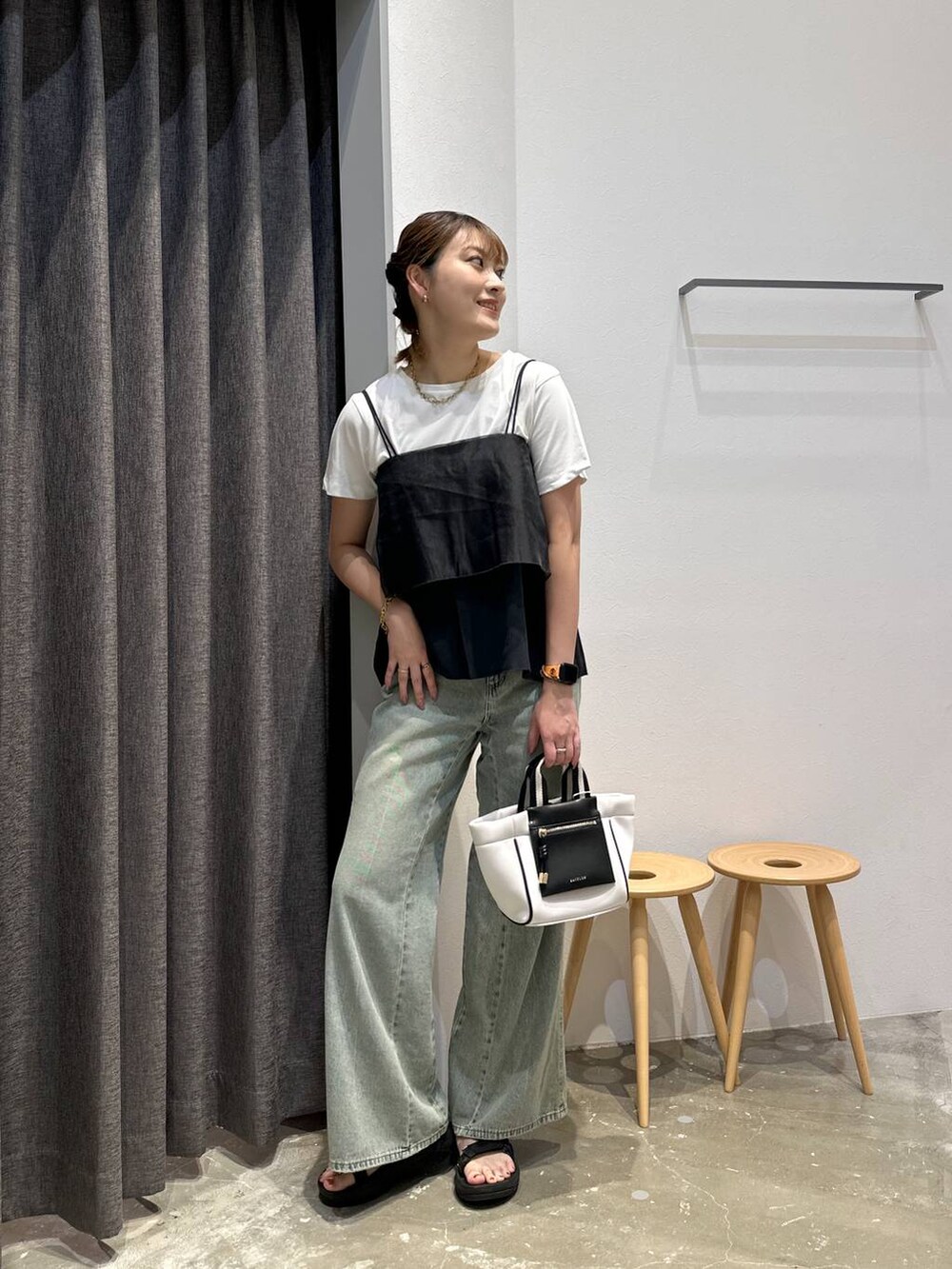 ホワイト系のショルダーバッグ、ブルー系のデニムパンツ、ブラック系のその他トップスを着用したレディースの夏コーディネートの4枚目の写真