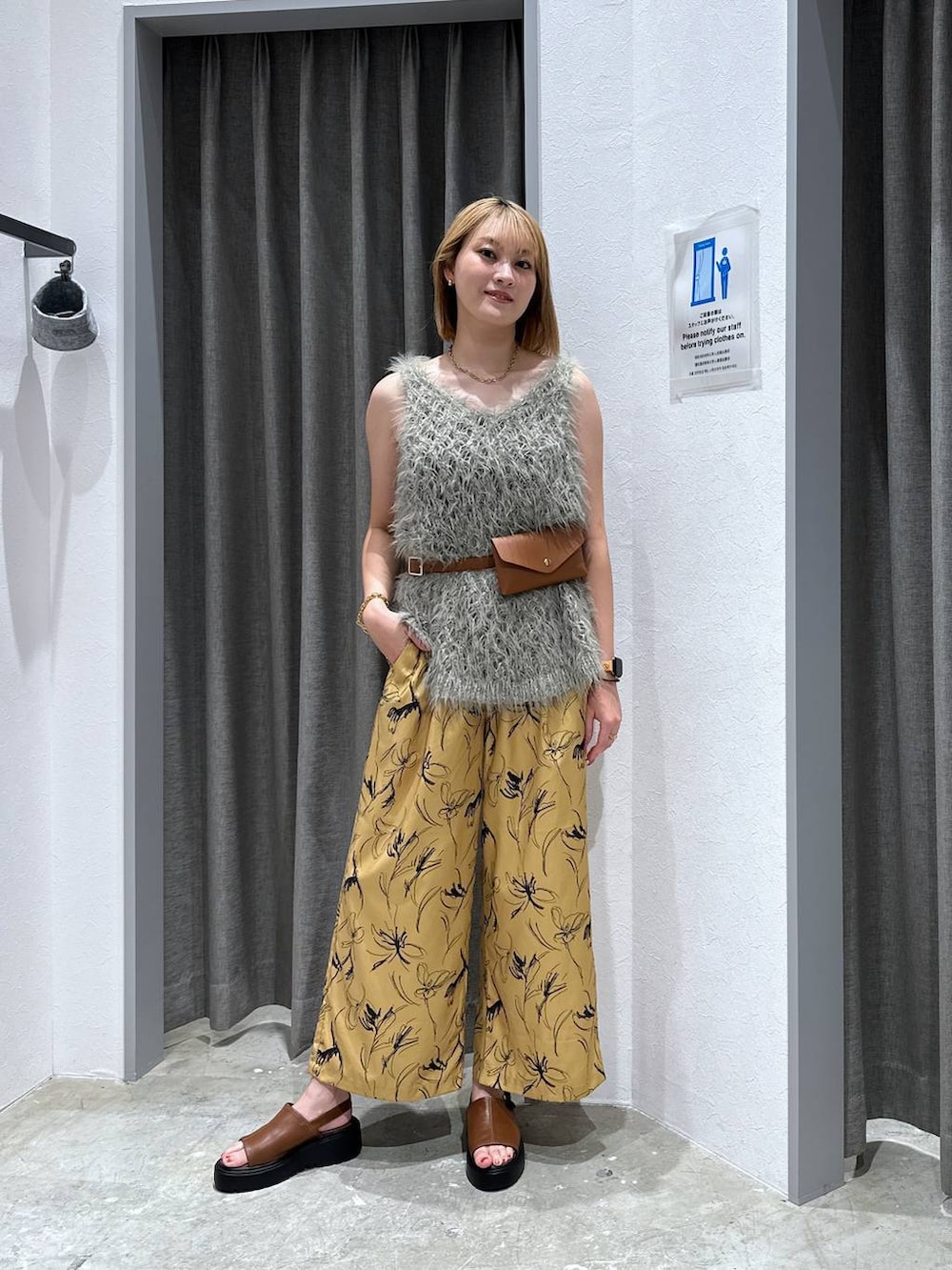 ブラウン系のサンダル、グレー系のベスト、イエロー系のボディバッグ/ウエストポーチを着用したレディースの夏コーディネートの4枚目の写真