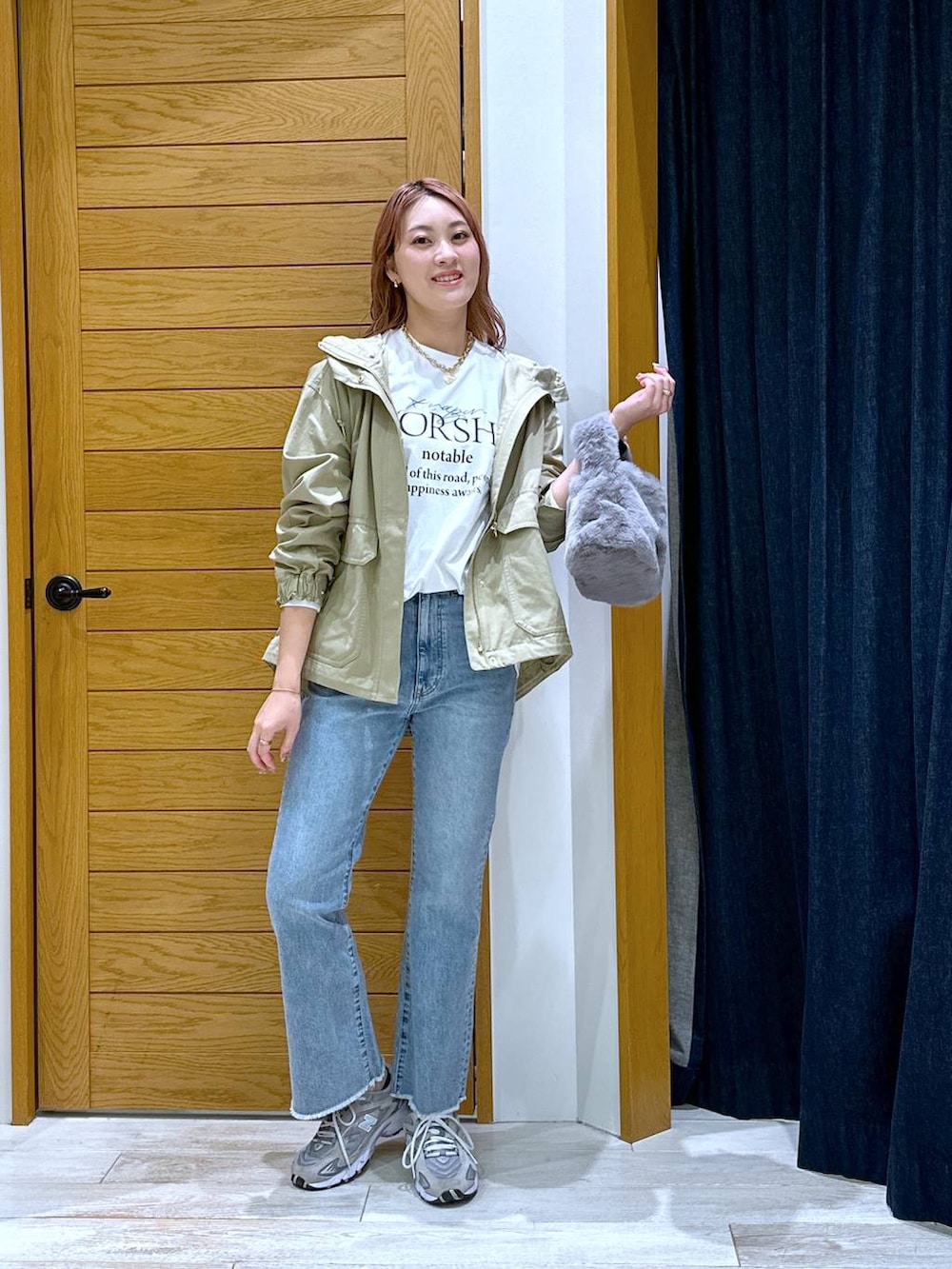 ブラウン系のマウンテンパーカー、ブルー系のデニムパンツ、ホワイト系のTシャツ/カットソーを着用したレディースの秋コーディネートの4枚目の写真