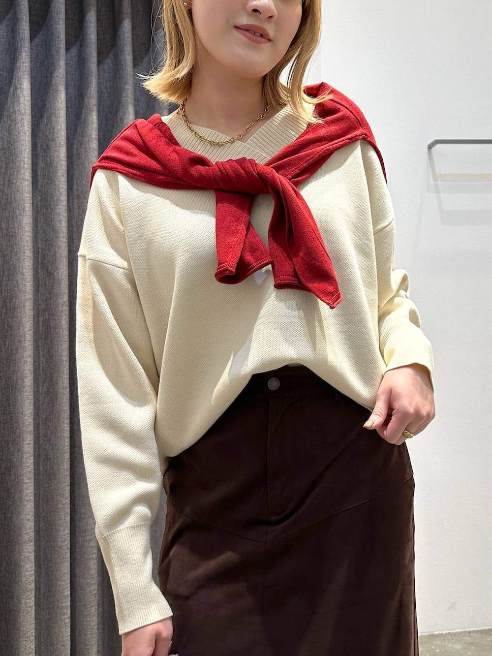 ブラウン系のスカート、ホワイト系のニット/セーター、ブラック系のトートバッグを着用したレディースの秋コーディネートの6枚目の写真