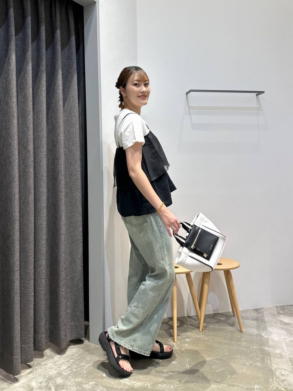 ホワイト系のショルダーバッグ、ブルー系のデニムパンツ、ブラック系のその他トップスを着用したレディースの夏コーディネートの2枚目の写真
