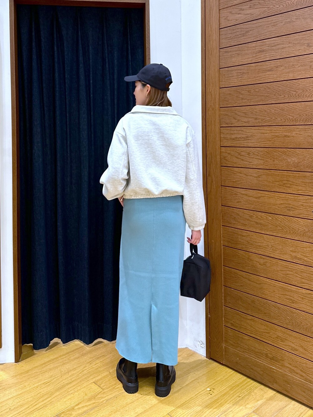 グレー系のスウェット、ホワイト系のTシャツ/カットソー、ブルー系のスカートを着用したレディースの冬コーディネートの3枚目の写真