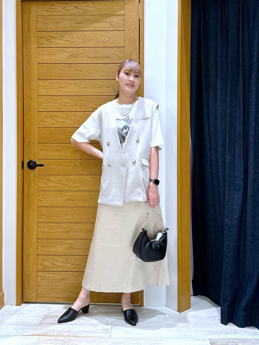 ホワイト系のTシャツ/カットソー、ブラック系のショルダーバッグ、ベージュ系のベストを着用したレディースの秋コーディネートの4枚目の写真