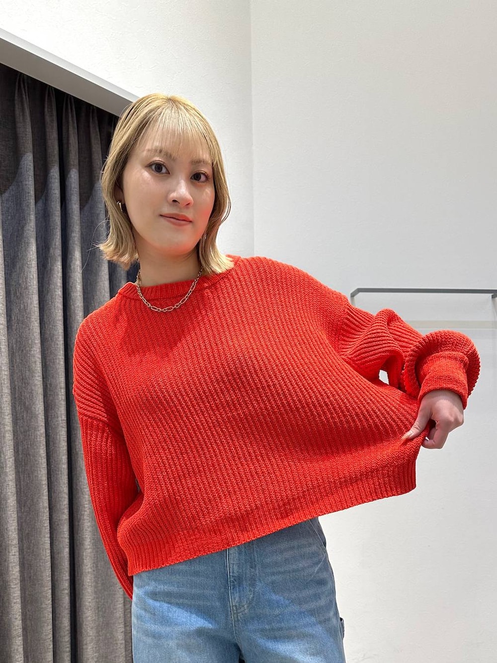 ブルー系のデニムパンツ、レッド系のニット/セーター、ブラック系のバックパック/リュックを着用したレディースの冬コーディネートの5枚目の写真