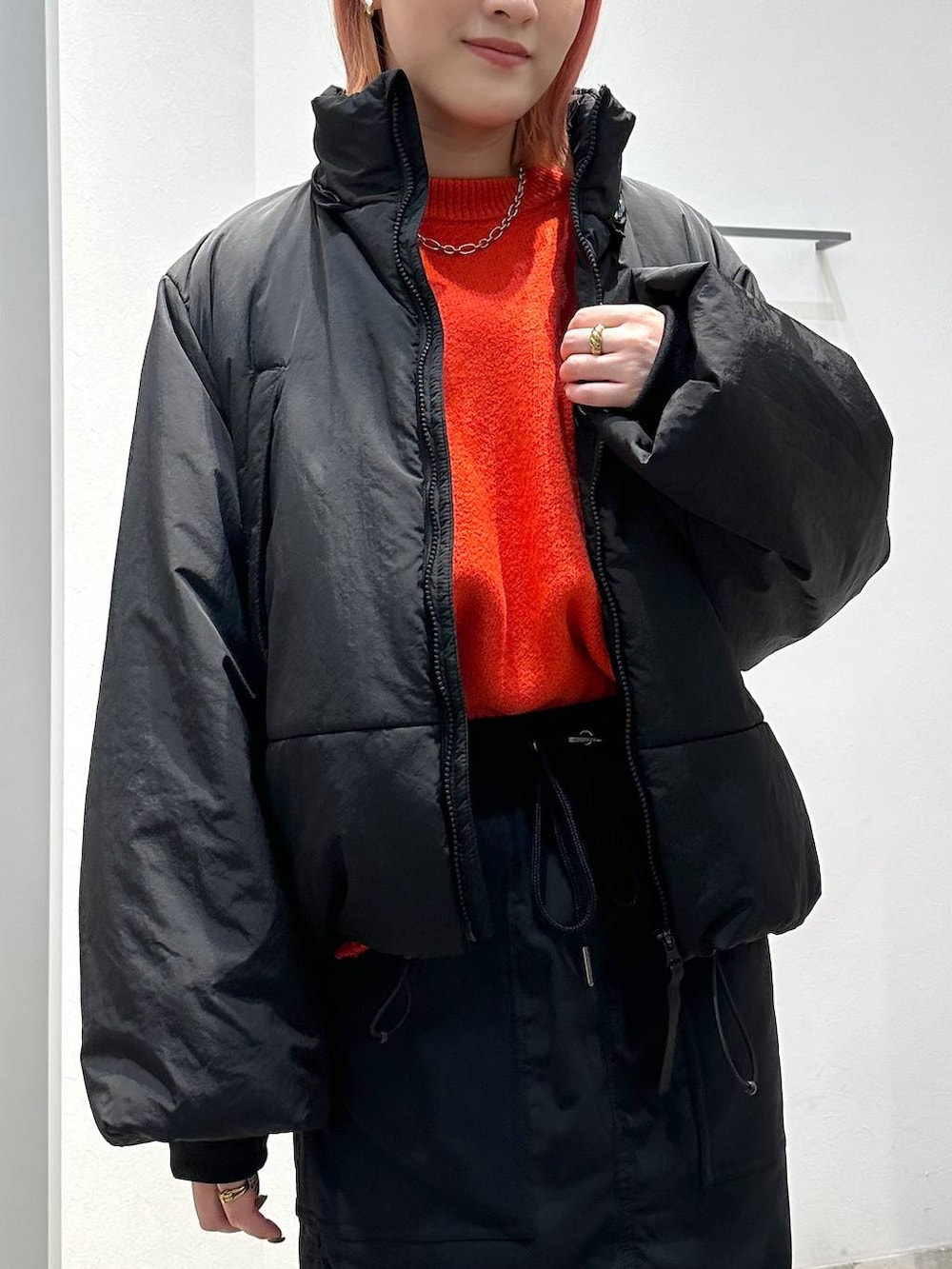 ブラック系のスカート、レッド系のニット/セーター、ブラック系のその他アウターを着用したレディースの秋コーディネートの4枚目の写真