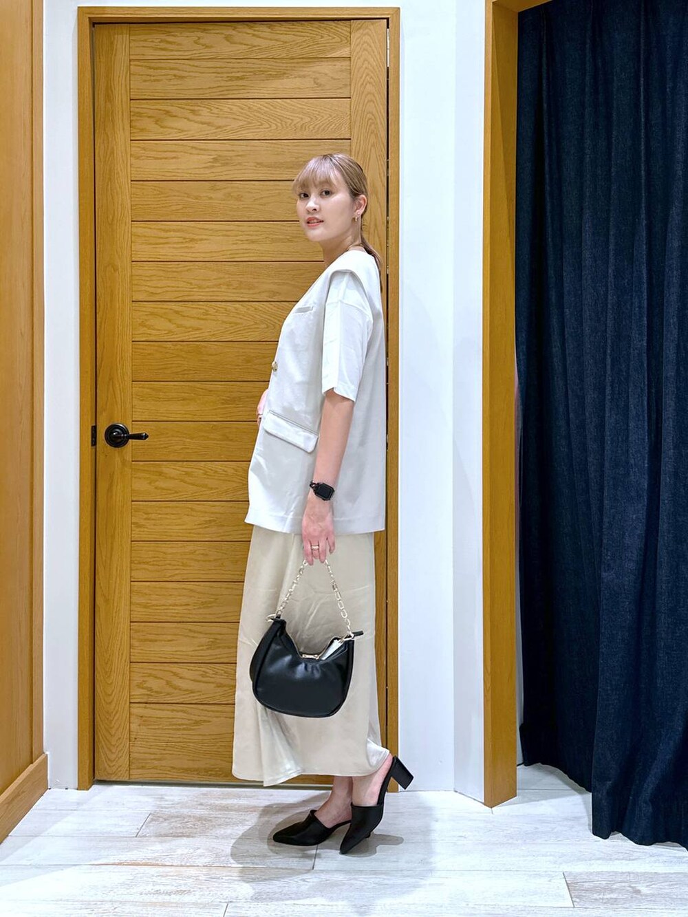 ホワイト系のTシャツ/カットソー、ブラック系のショルダーバッグ、ベージュ系のベストを着用したレディースの秋コーディネートの2枚目の写真