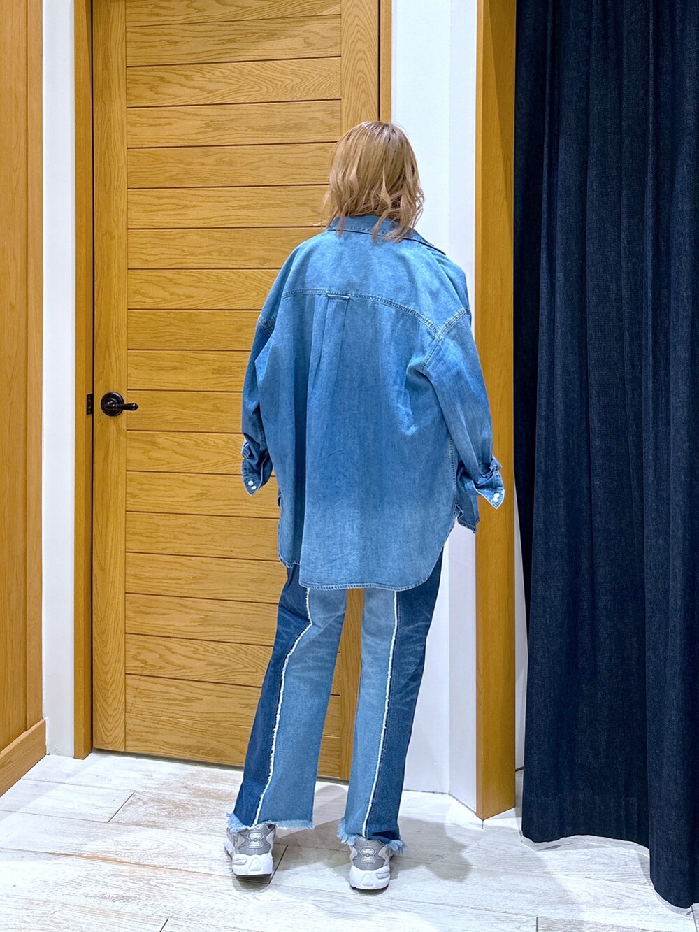 ブルー系のデニムパンツ、グレー系のニット/セーター、ブルー系のシャツ/ブラウスを着用したレディースの冬コーディネートの3枚目の写真