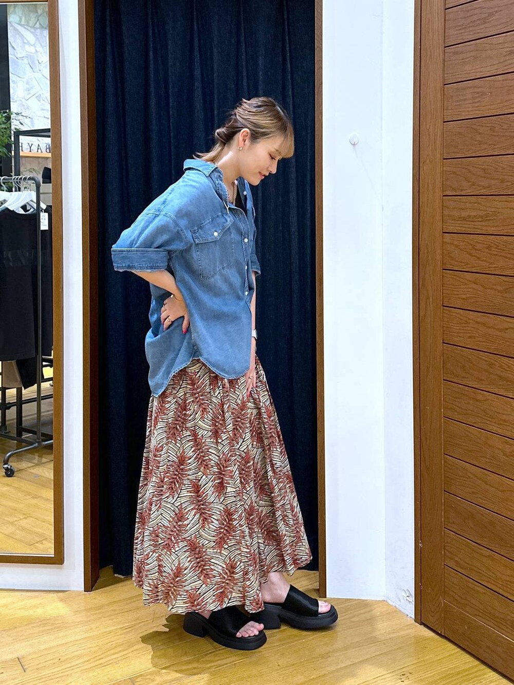 ブラック系のサンダル、オレンジ系のスカート、ブルー系のシャツ/ブラウスを着用したレディースの夏コーディネートの2枚目の写真