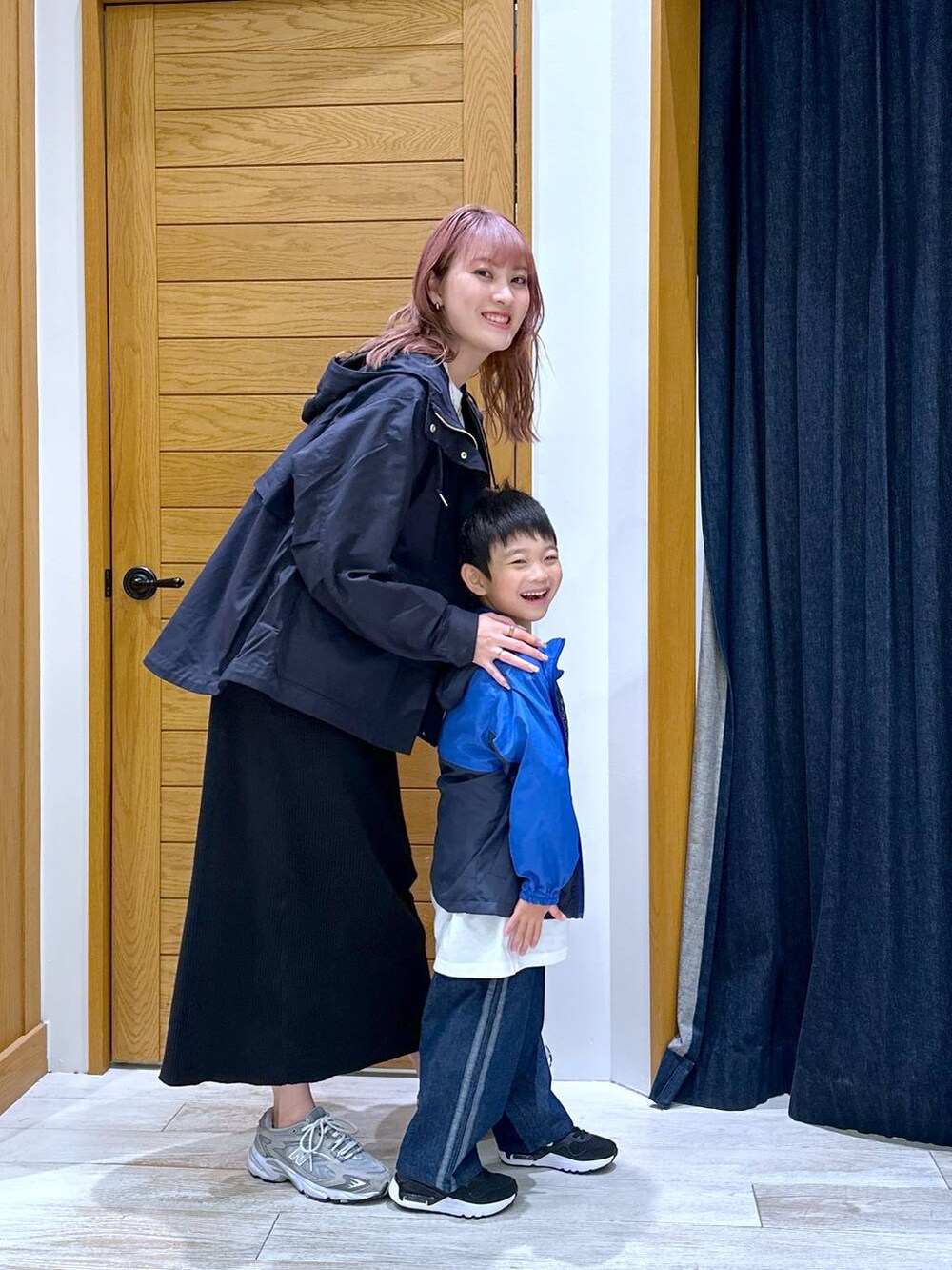 ブラック系のスカート、ブルー系のマウンテンパーカー、ホワイト系のショルダーバッグを着用したキッズの秋コーディネートの2枚目の写真