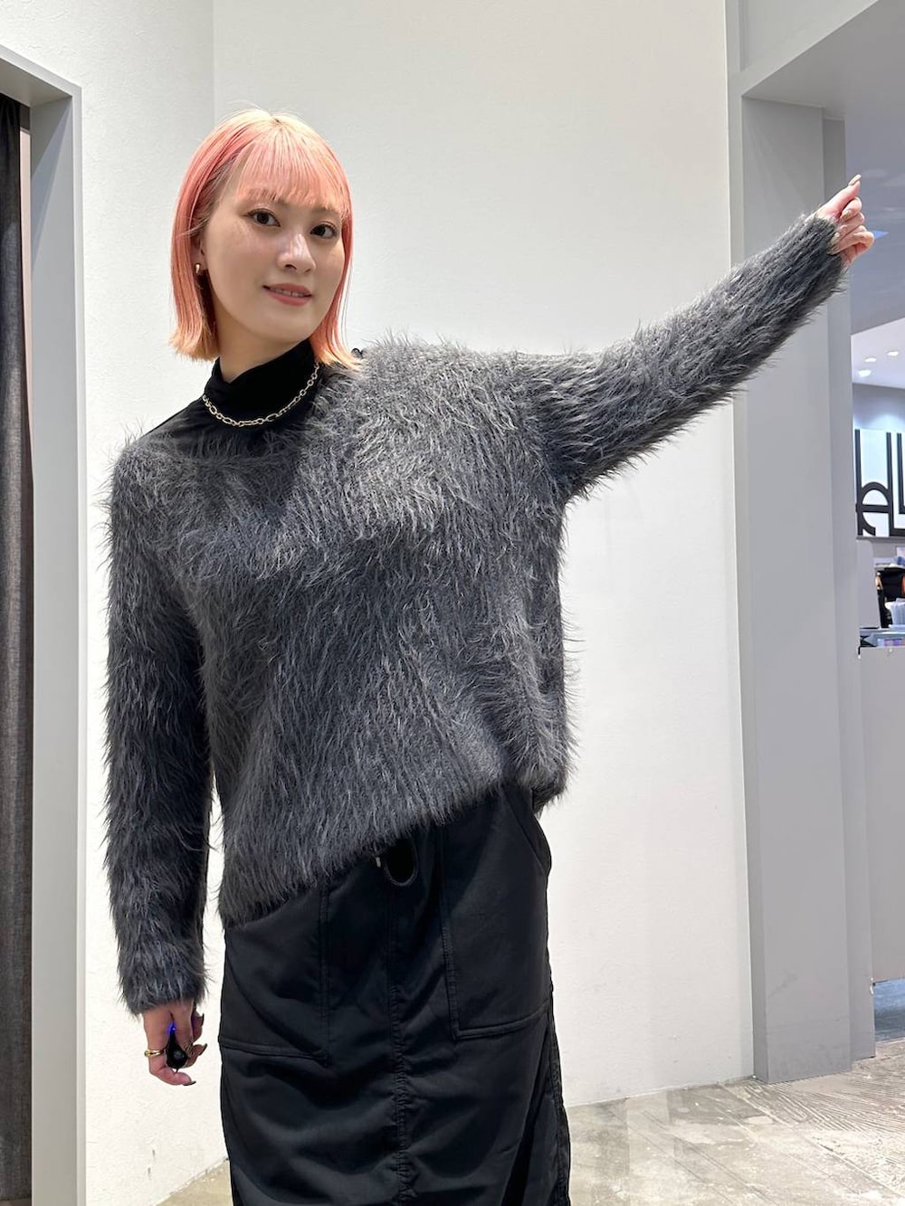 ブラック系のスカート、ブラック系のブーツ、ブラック系のTシャツ/カットソーを着用したレディースの秋コーディネートの5枚目の写真