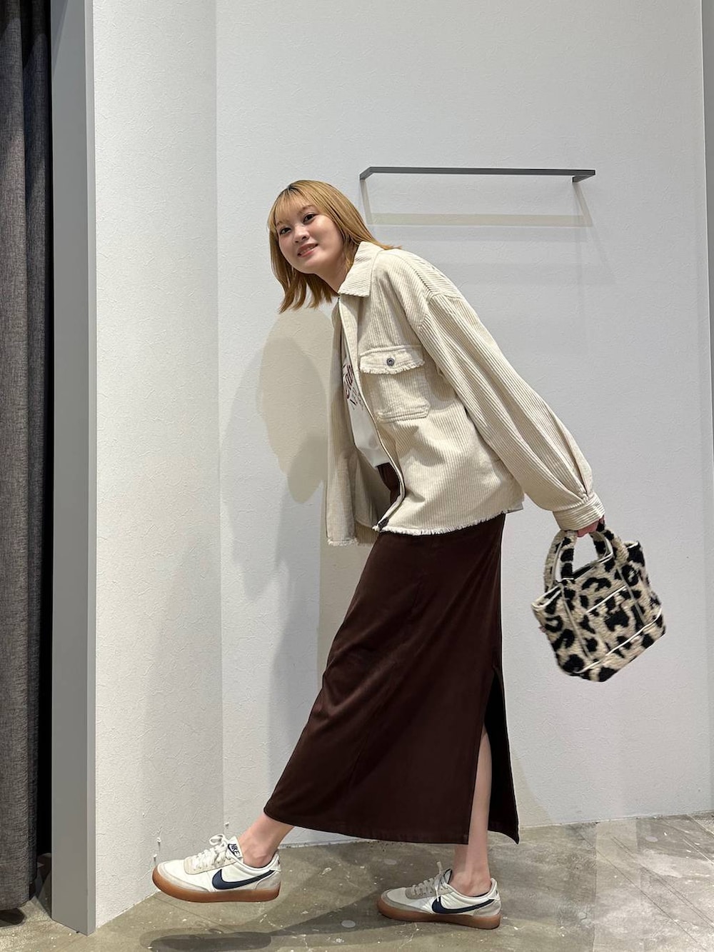 ブラウン系のスカート、ホワイト系のTシャツ/カットソー、ホワイト系のブルゾンを着用したレディースの秋コーディネートの4枚目の写真