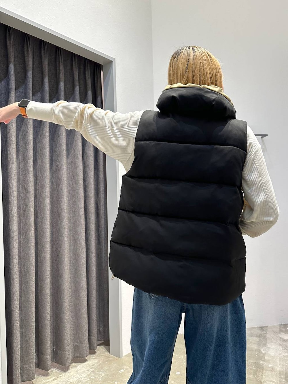 ベージュ系のトートバッグ、ブラック系のベスト、ホワイト系のTシャツ/カットソーを着用したレディースの秋コーディネートの5枚目の写真