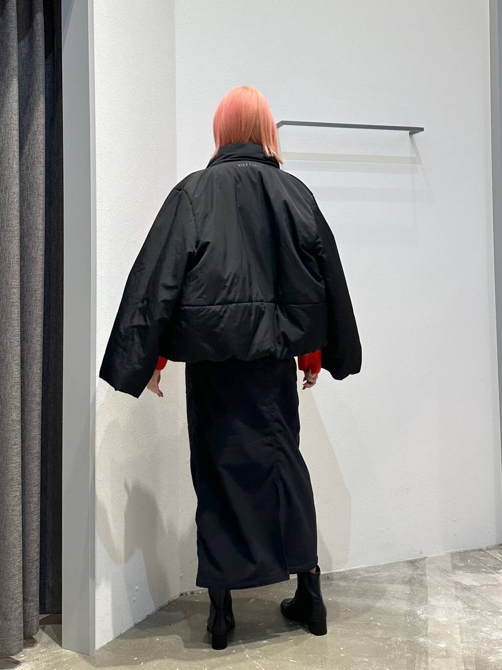 ブラック系のスカート、レッド系のニット/セーター、ブラック系のその他アウターを着用したレディースの秋コーディネートの3枚目の写真